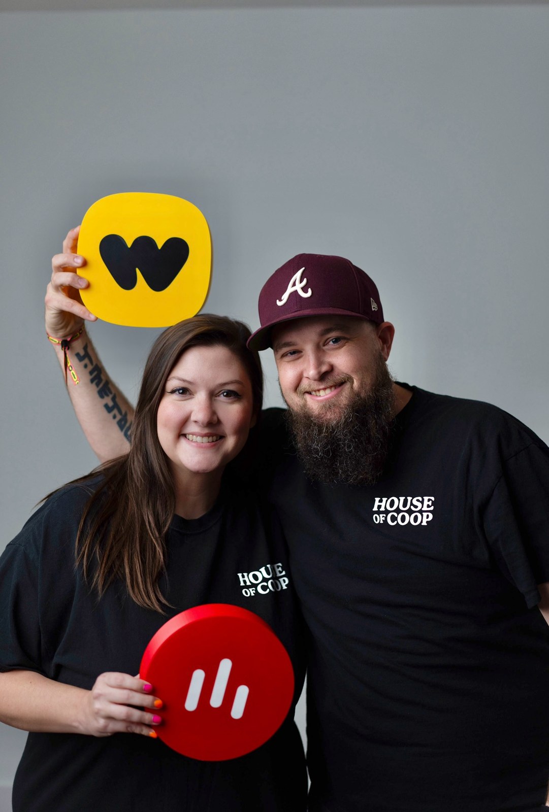 Ashley and Jacob holding a yellow Whatnot sign and a red livestream sign